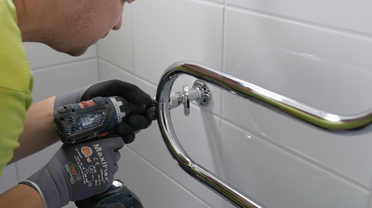 Peter installerar en handdukstork vid en badrumsrenovering i Danderyd.